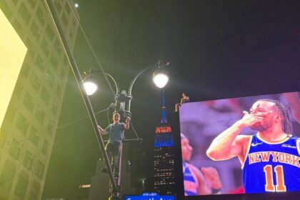 Knicks fanai ant gatvės lempų ir reklaminių stendų