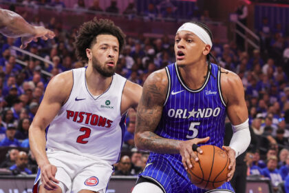 Detroit Pistons guard #2 confronts an Orlando Magic guard #5 in a blue pinstripe jersey as they contest a loose ball during a game.