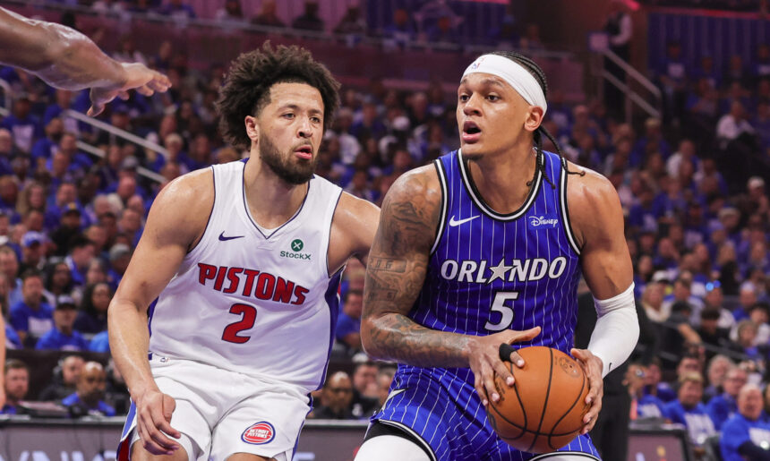 Detroit Pistons guard #2 confronts an Orlando Magic guard #5 in a blue pinstripe jersey as they contest a loose ball during a game.