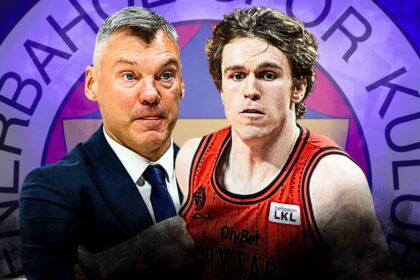 Coach in a dark suit and a basketball player in a red jersey stand side by side in front of a purple circular logo backdrop.