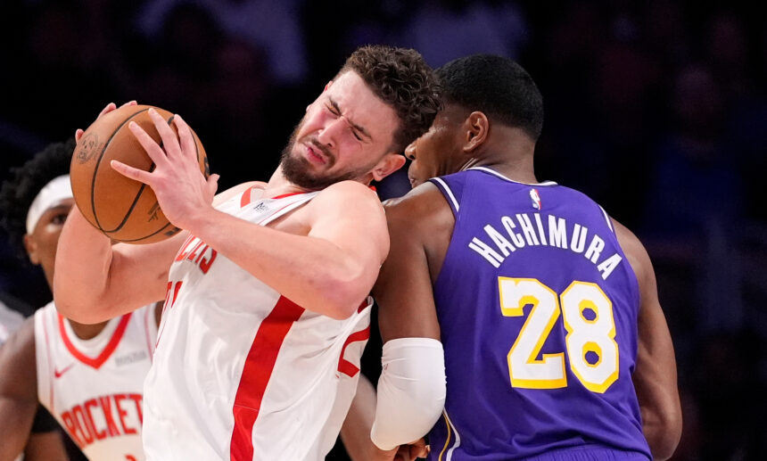 Two basketball players collide as they fight for the ball: one in a white uniform with red stripes, the other in a purple jersey number 28 (Hachimura).