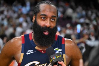 Basketball player with a full beard being interviewed on court, holding a microphone labeled NBC Sports.