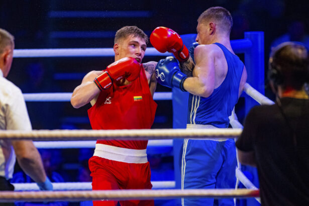 Red boxer lands a punch on the blue opponent in the ring during a boxing match.