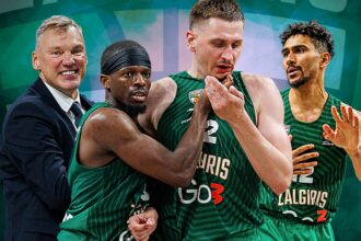 Coach in a suit stands with three Zalgiris basketball players in green jerseys, all celebrating together on the court.