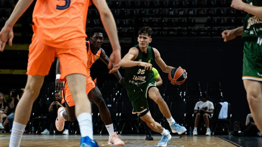 Basketball player in green jersey (number 35) dribbles past defenders on a court during a game, orange-clad opponents nearby.