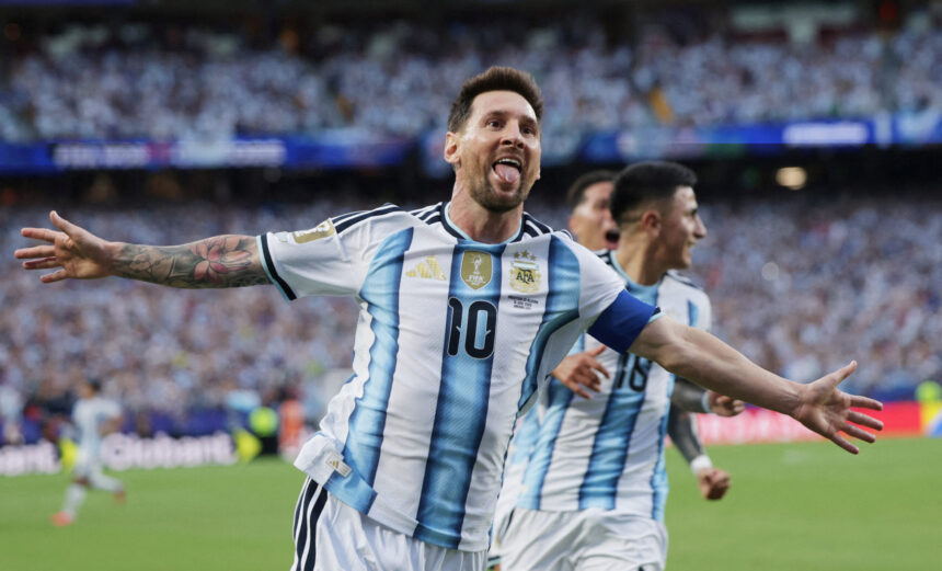 Argentinian soccer player celebrating with arms wide on the field in a blue-and-white striped jersey (number 10).
