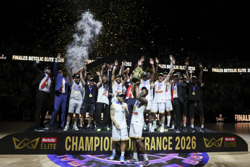 Basketball team on stage celebrating with trophy and medals as confetti falls during the Finales Betclic Elite 2026 celebration.