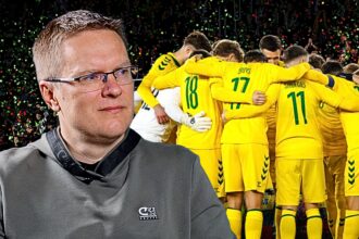Man in a gray shirt with glasses in the foreground as a yellow-clad soccer team celebrates in a huddle behind him with confetti in the stands.