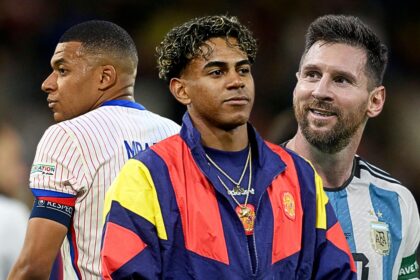 Three soccer players stand together on the field in different national team jerseys.