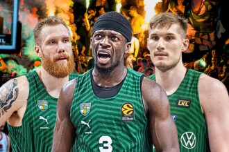 Three basketball players in green jerseys stand together on a court with a cheering crowd and flaming pyrotechnics behind them, celebrating.