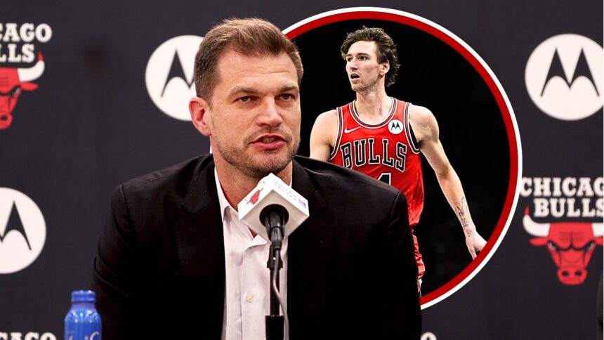 Man in a suit speaking at a press conference, microphone in front, with Chicago Bulls branding in the background with a Bulls cutout.