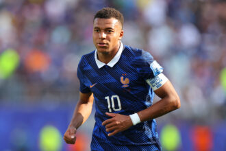 France national team footballer in a blue kit, number 10, running on the pitch during a match.