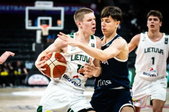 Two Lithuanian basketball players scrabble for the ball in white uniforms, one being defended by a dark-clad opponent near the hoop area.