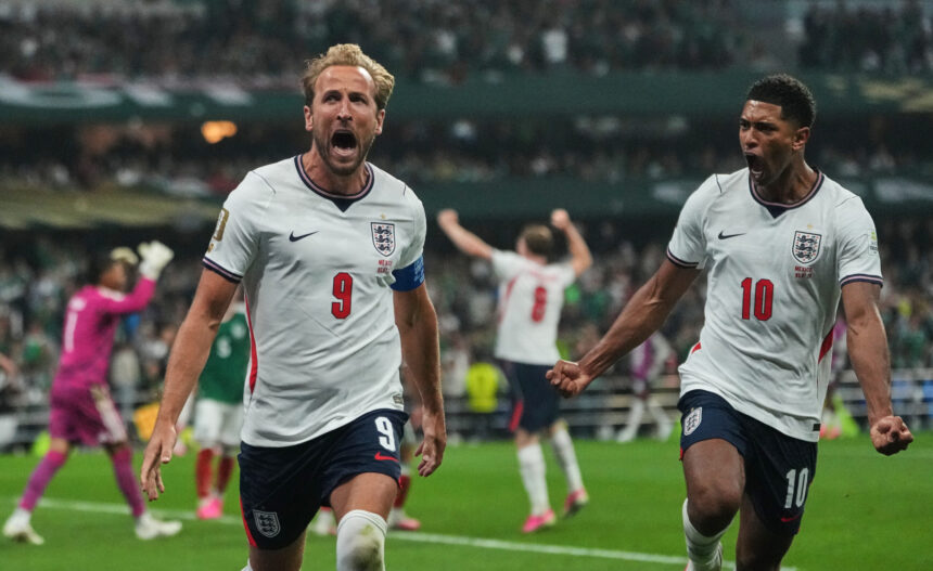 England footballers celebrate a goal, front two players wearing number 9 and number 10 jerseys on the pitch.
