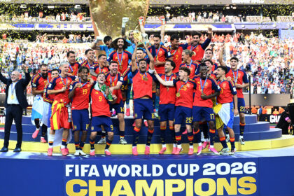 Spain national football team celebrates on podium with trophy and gold medals as confetti falls, FIFA World Cup 2026 champions.
