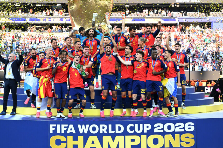 Spain national football team celebrates on podium with trophy and gold medals as confetti falls, FIFA World Cup 2026 champions.