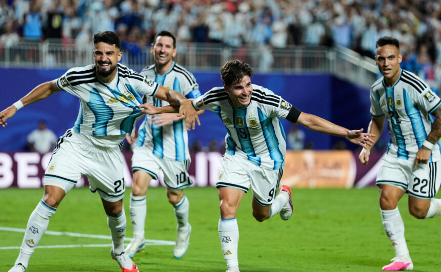 Argentina men’s soccer players celebrate running on the field during a match, blue-and-white striped jerseys and cheering crowd in the background